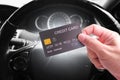 Credit cards and financial privileges concept, hand holding luxury credit or debit card with a steering wheel background in a car Royalty Free Stock Photo