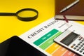 Credit rating on a yellow table, pen, magnifier, notebook Royalty Free Stock Photo