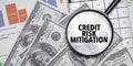 CREDIT RISK MITIGATION words on magnifier glass with dollars and charts