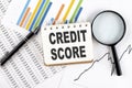CREDIT SCORE text on notebook on the graph background with pen and magnifier Royalty Free Stock Photo