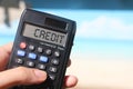 Credit word on calculator display on relaxed beach background. Concept for business and Finance Royalty Free Stock Photo