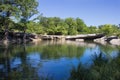 A creek basin bordered by limestone and trees Royalty Free Stock Photo