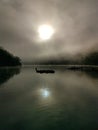 Beautiful view of creek with reflections blue sky, light clouds, fog, mountains and trees on water Royalty Free Stock Photo