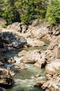 Creek flowing through along rocks and river Royalty Free Stock Photo