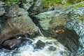 Creek with flushing water eroding a slate rock