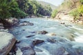 Creek and river flowing through along rocks Royalty Free Stock Photo