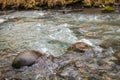 The creek, Water flows on stones. Bubbles and foam on the water. Abstract natural background in selective focus