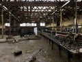 Creepy abandoned factory floor with broken equipment.