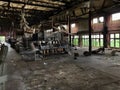 A creepy abandoned factory floor with broken machines .