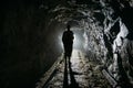 Creepy backlit human silhouette inside dark abandoned mine