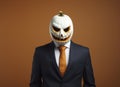 Creepy businessman wearing a carved pumpkin mask. Royalty Free Stock Photo