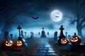 Creepy cemetery scene illuminated by glowing pumpkins and the mystical glow of the moon