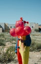 Creepy clown with a bunch of balloons