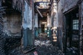 Creepy corridor of burnt abandoned building. Ruined ceiling and roof Royalty Free Stock Photo