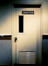 Creepy Dark Dirty Door with Janitor Sign on It on The Corner and Dim Sunlight.