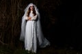 Creepy dead bride at night in a swamp. Halloween scene