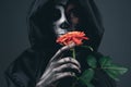 Creepy female in black cape with red rose Royalty Free Stock Photo
