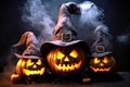 Creepy Halloween grinning pumpkins glow in the dark among the fog. jack-o-lantern in a witch hat on a black background in smoke