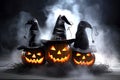 Creepy Halloween grinning pumpkins glow in the dark among the fog. jack-o-lantern in a witch hat on a black background in smoke