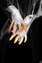 Creepy halloween hands with red, orange and silver covered in a spider web with spiders