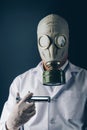 A scary doctor in gas mask with a big stainless steel syringe