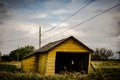 Creepy, old and aged abandoned wooden barn in a field under the cloudy and rainy sky Royalty Free Stock Photo