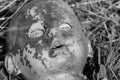 Creepy old doll head. Broken abandoned damaged scary toy in a garbage dump