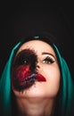 Creepy portrait of a woman with a cursed mark on her face on dark background with copy space Royalty Free Stock Photo