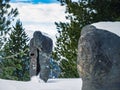 Creepy scary gothic snow covered statue of a spirit ghost on a mountain in a forest during winter Royalty Free Stock Photo