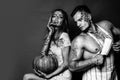 Creepy scary halloween vampire girl and big muscular man looking camera and holding pumpkin. Horror photo of sexy girl