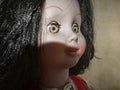 Creepy scary old vintage doll face with black hair smiling Royalty Free Stock Photo