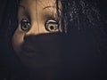 Creepy scary old vintage doll face with black hair smiling Royalty Free Stock Photo