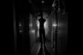 Creepy silhouette in the dark abandoned building. Horror Halloween concept. Dark corridor with silhouette of horror person standin