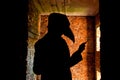 Creepy silhouette of plague doctor on red brick background