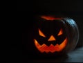 Creepy smiling pumpkin for Halloween on black background.