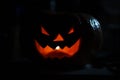 Creepy smiling pumpkin for Halloween on black background.