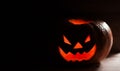 Creepy smiling pumpkin for Halloween on black background.