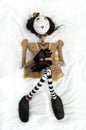 Creepy steampunk doll lying on back knees raised. Vertical.