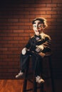 Scary ventriloquist doll sitting on a stool