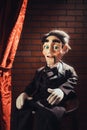 Scary ventriloquist doll sitting on a stool