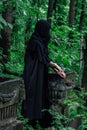 Creepy witch in black in spooky abandoned cemetery Royalty Free Stock Photo