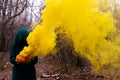 A creepy witch holds a steaming pumpkin in a deep forest. Jack o lantern emits yellow smoke for halloween Royalty Free Stock Photo