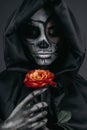 Terrifying female with skull face and red flower Royalty Free Stock Photo