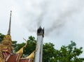 Crematorium and smoke with green tree background and white cloudy feel so sad at Wat Cheung Hawaii, Pitsanulok,north of Thailand.