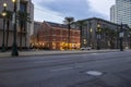 The Creole House Restaurant and Oyster Bar on Canal Street with cars driving on the street, lush green palm trees