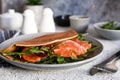 Crepe with arugula and salmon for breakfast on the kitchen table. Good morning