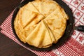 Crepe closeup, thin pancake on a frying pan, wood background