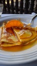 Crepe suzette, tasty pancakes with orange sauce on white plate, AI generative