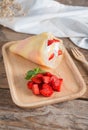 Crepes cake roll cream cheese with strawberry on wood plate. Royalty Free Stock Photo