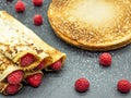 Crepes filled with raspberry jam and fresh raspberry on slate